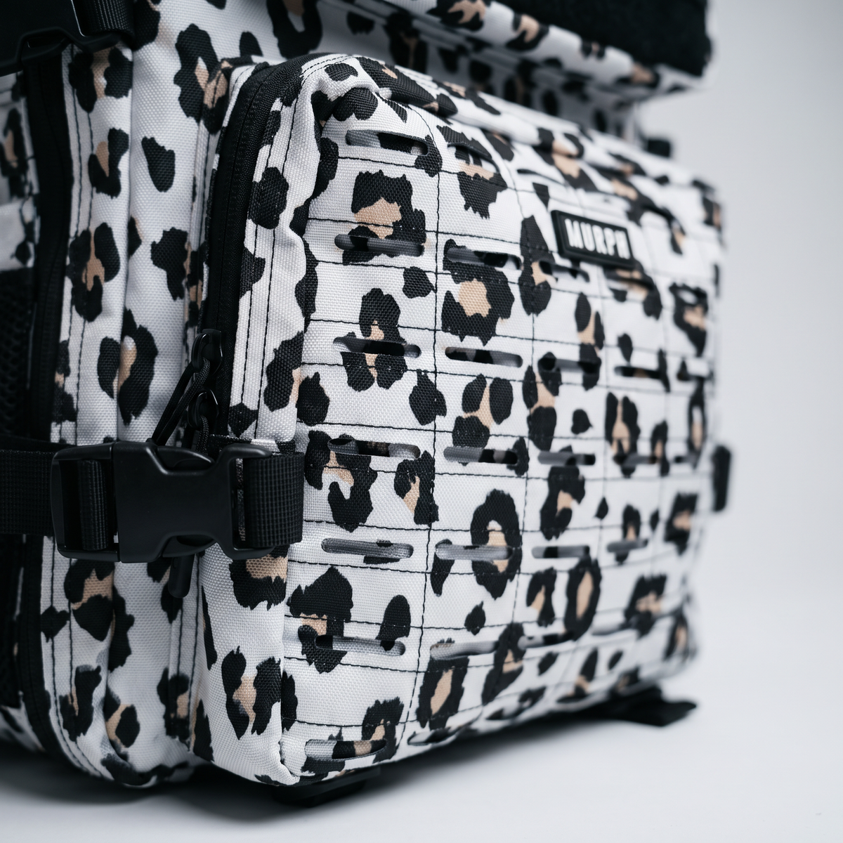 Gros plan du système MOLLE latéral du sac Murph Hero 25L léopard