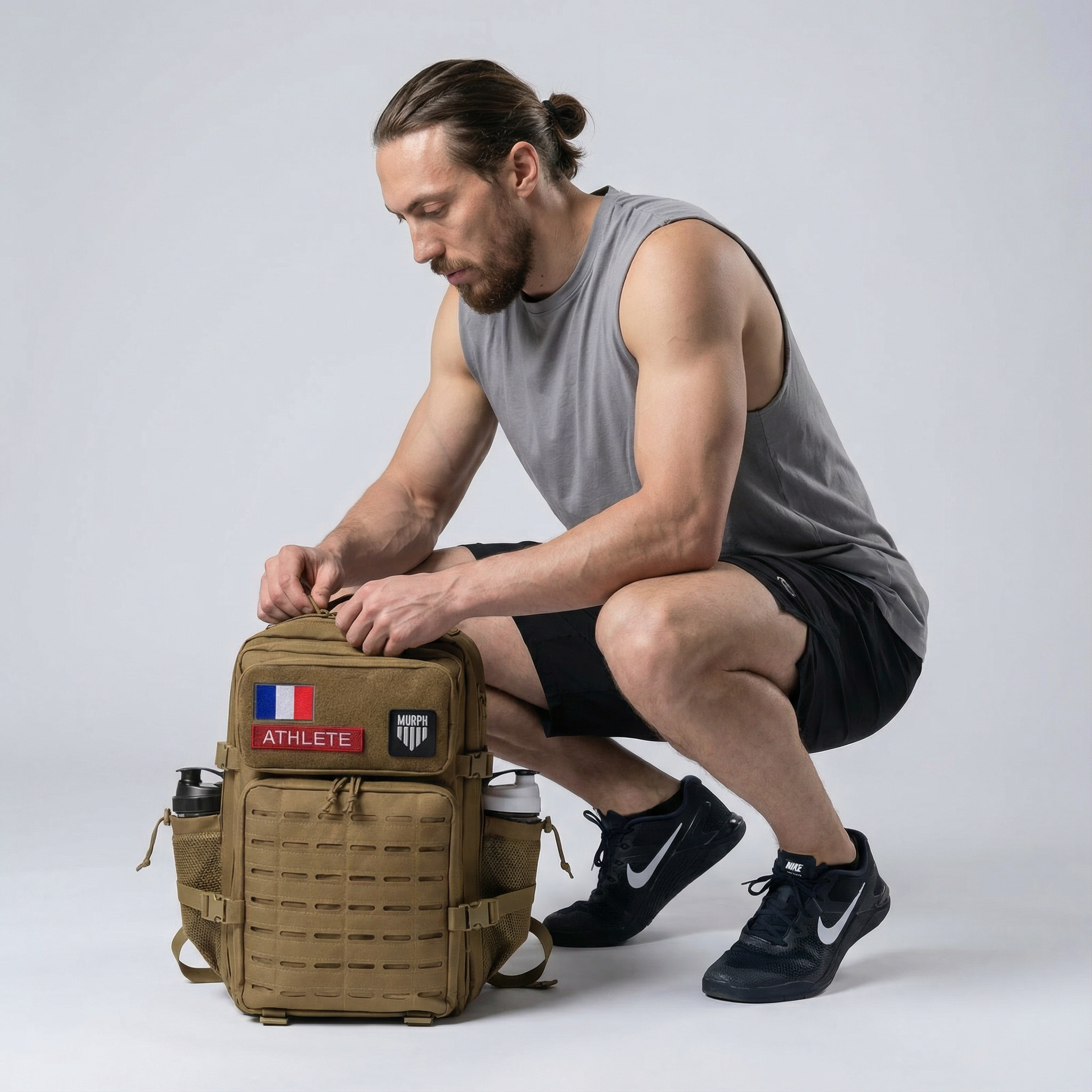 Sac à Dos CrossFit 45L Marron Hero Murph - Athlète Ouvrant le Sac avec Patchs