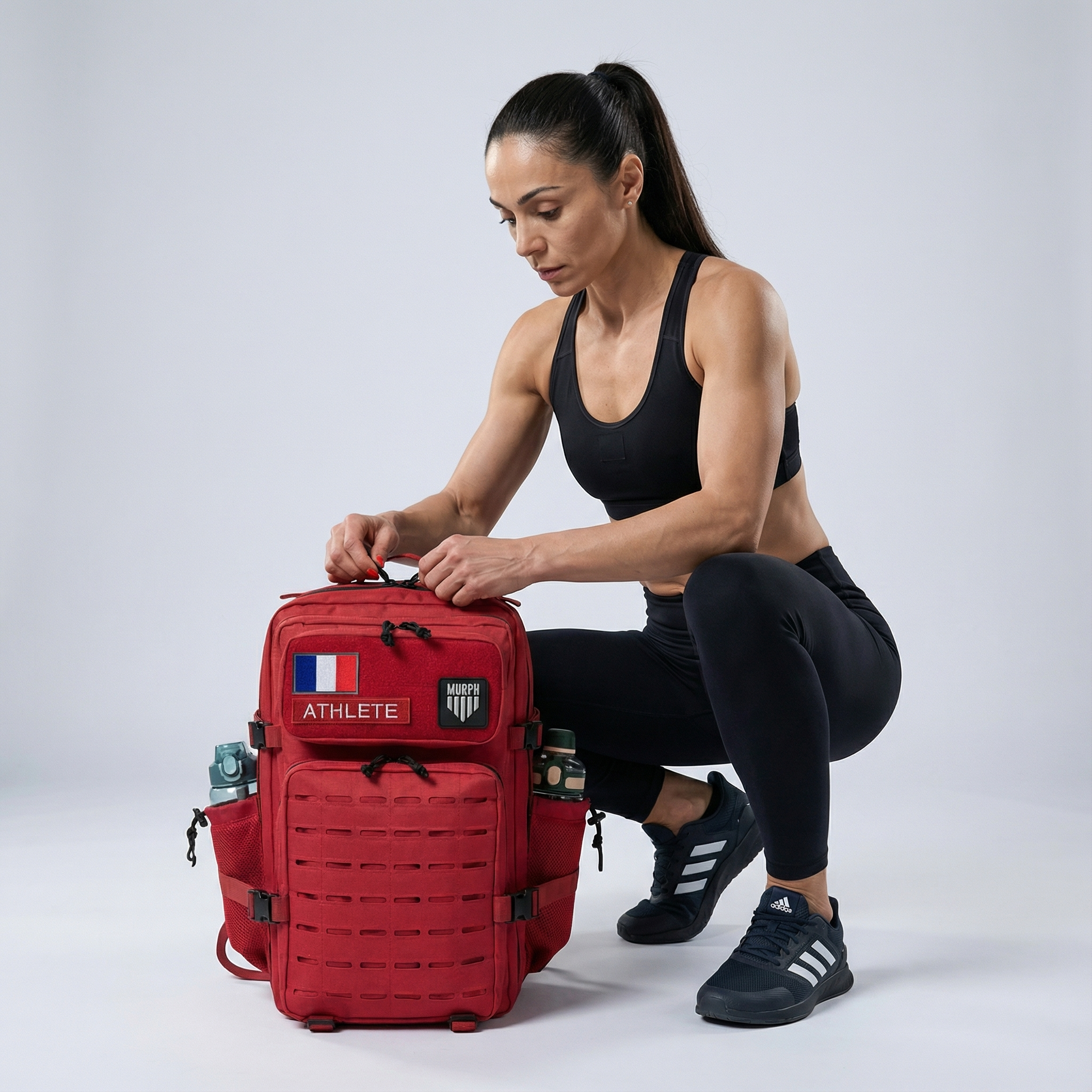 Sac à Dos CrossFit 45L Rouge Hero Murph - Athlète Femme Ouvrant le Sac avec Patchs