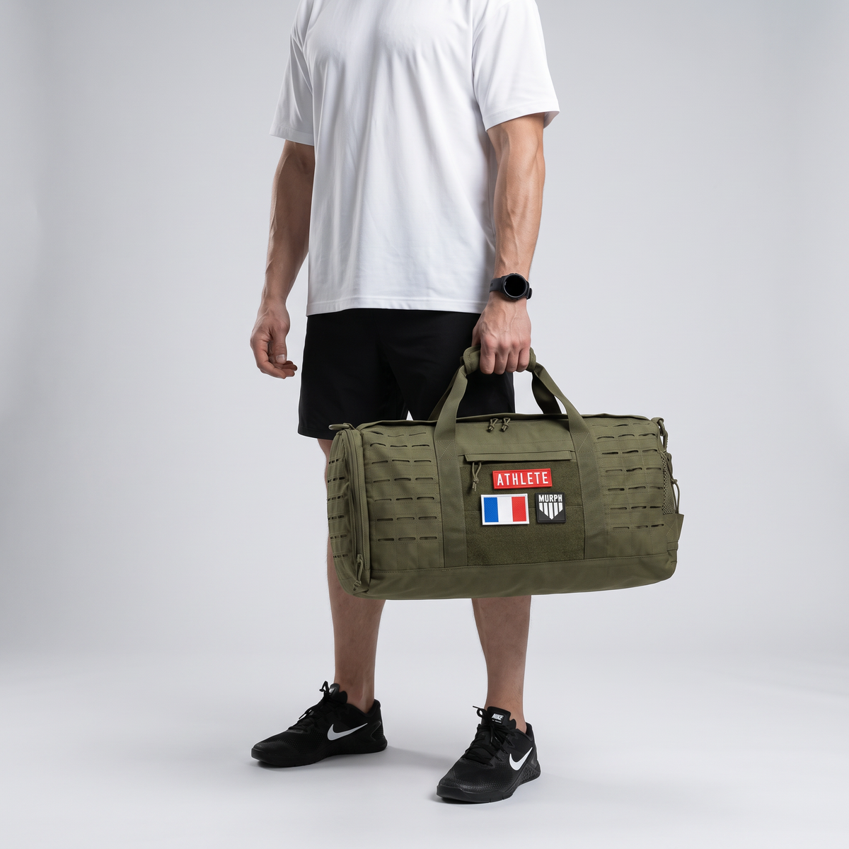 Athlete portant le sac polochon tactique Murph kaki a la main